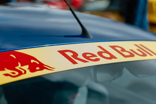 a close up of a red bull logo on a blue car