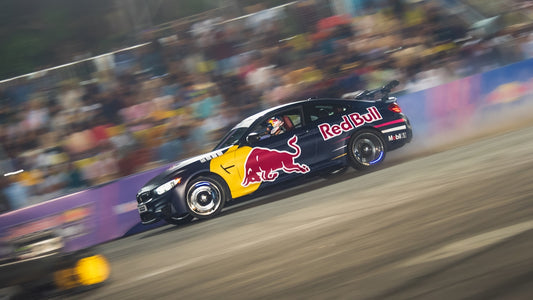 Race car with red bull logos drifting on track